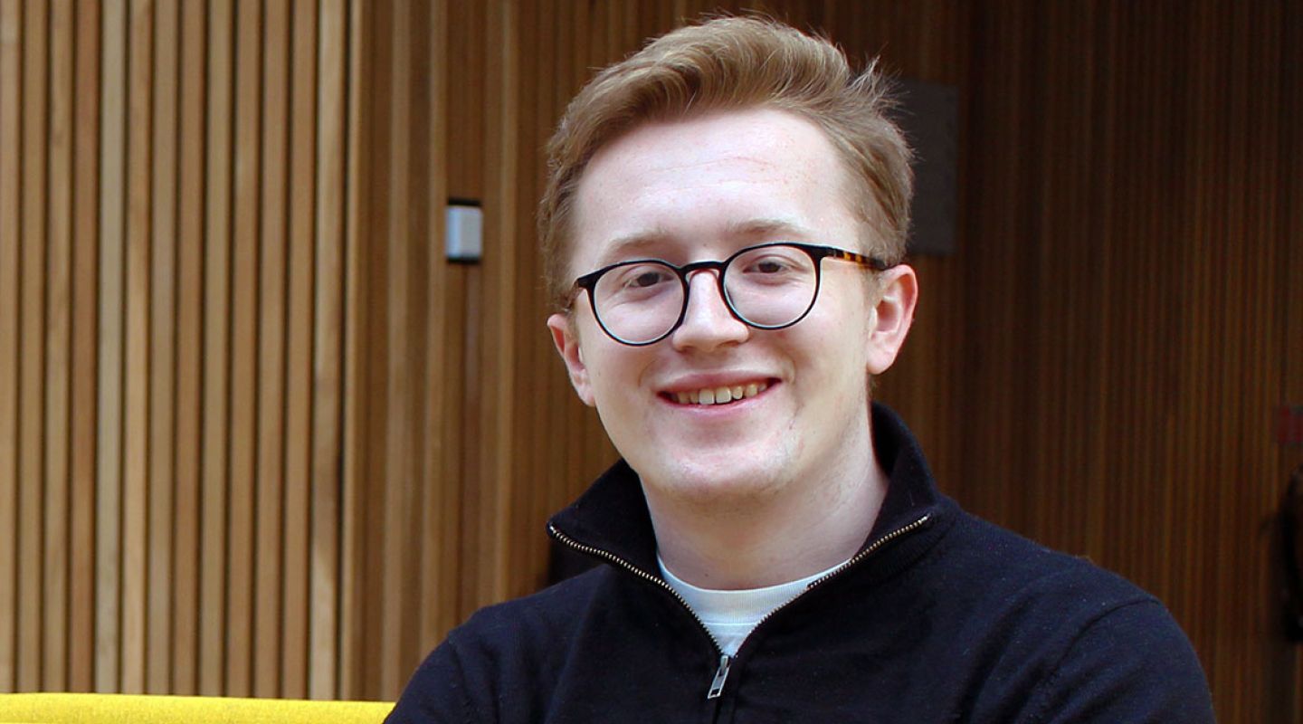 Tom smiling in the city law school foyer.