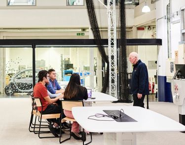 Photo of a group of students speaking to staff member in the Engineering labs