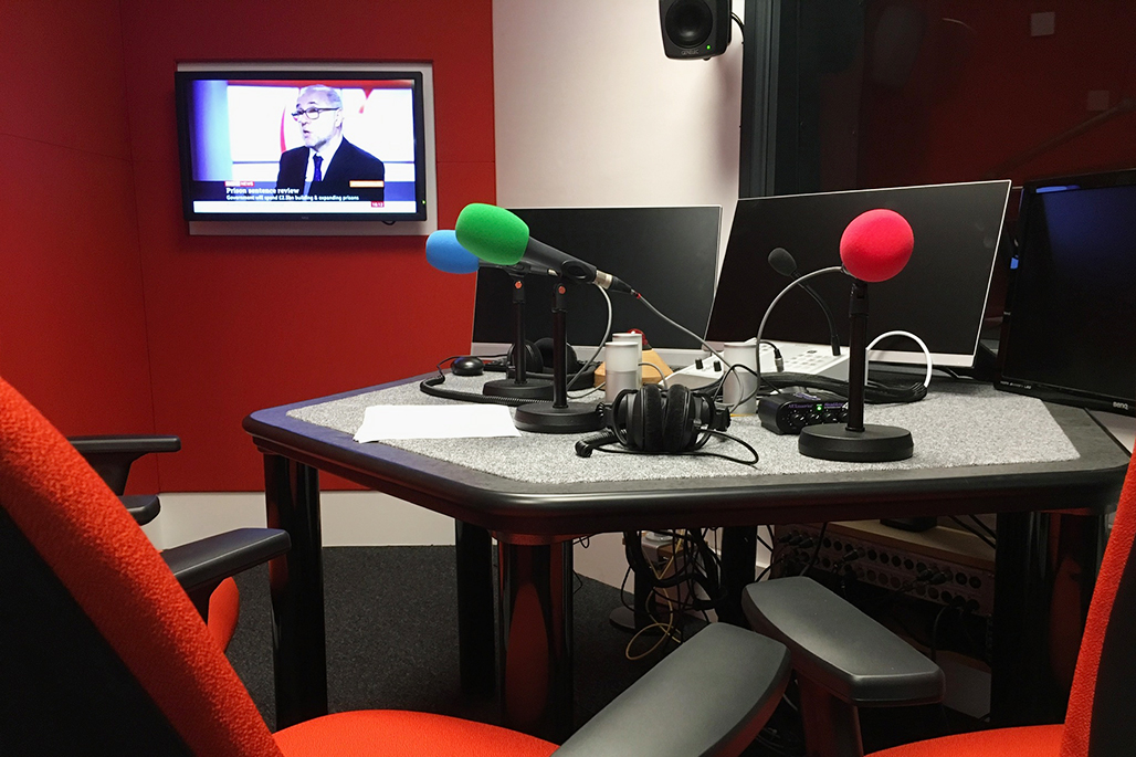 Journalism Newsroom with computers and mics