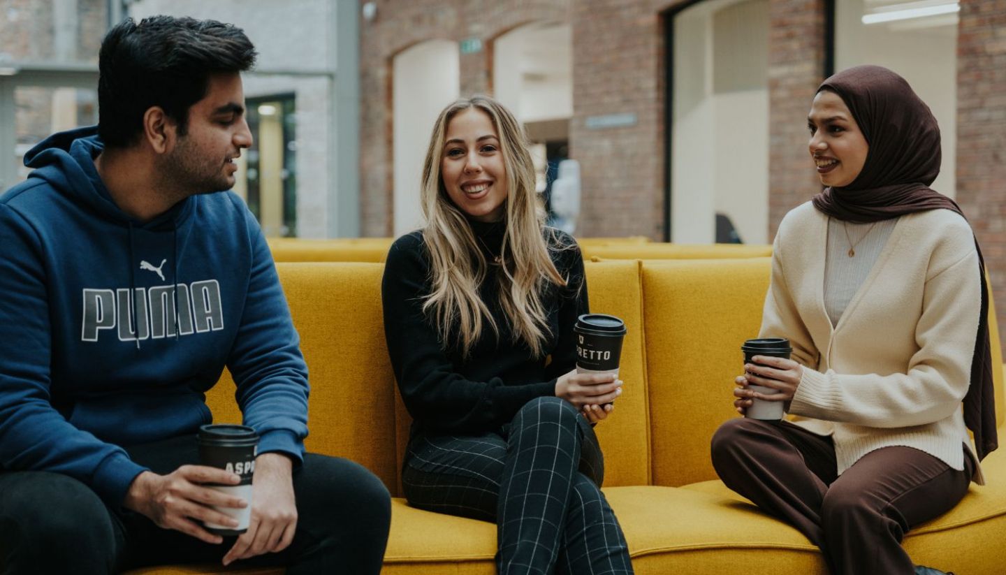 A group of students sitting in the Law building smiling and chatting