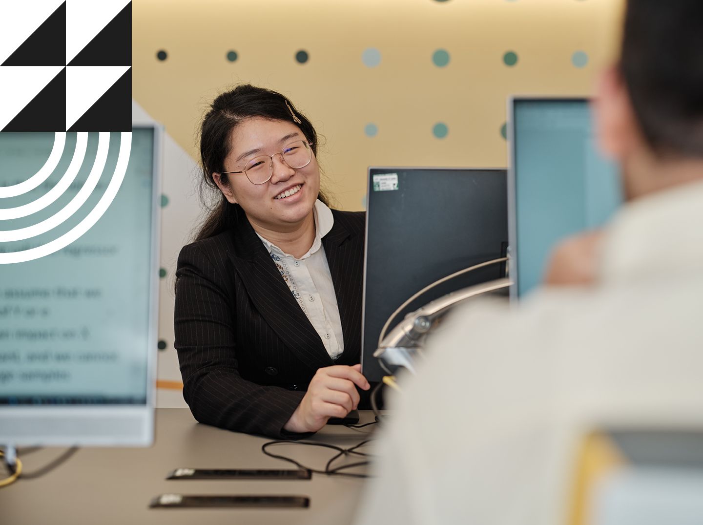 Female student smiling in front of a computer