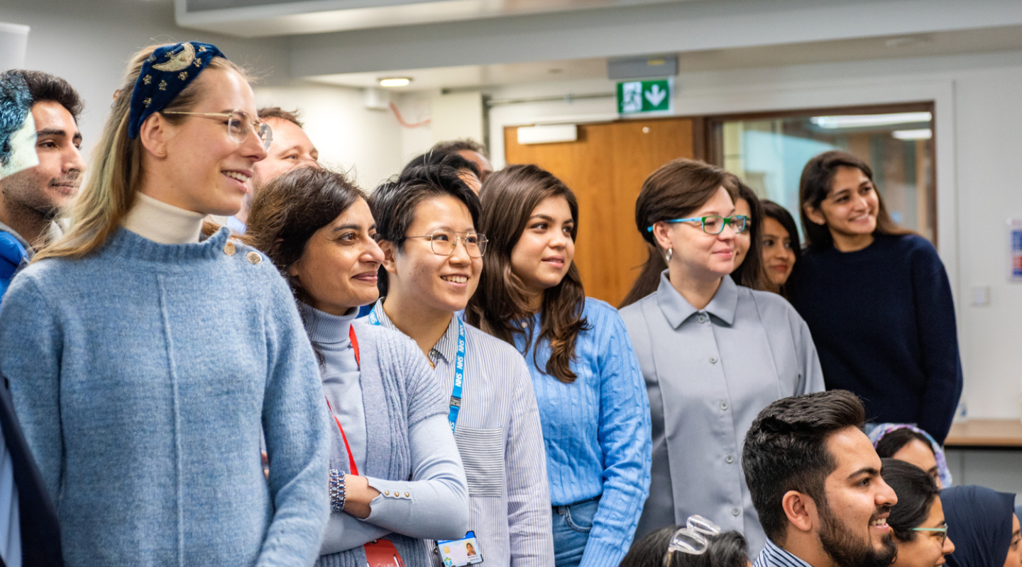 Students and academics standing with a few kneeling in the front for a group photograph.
