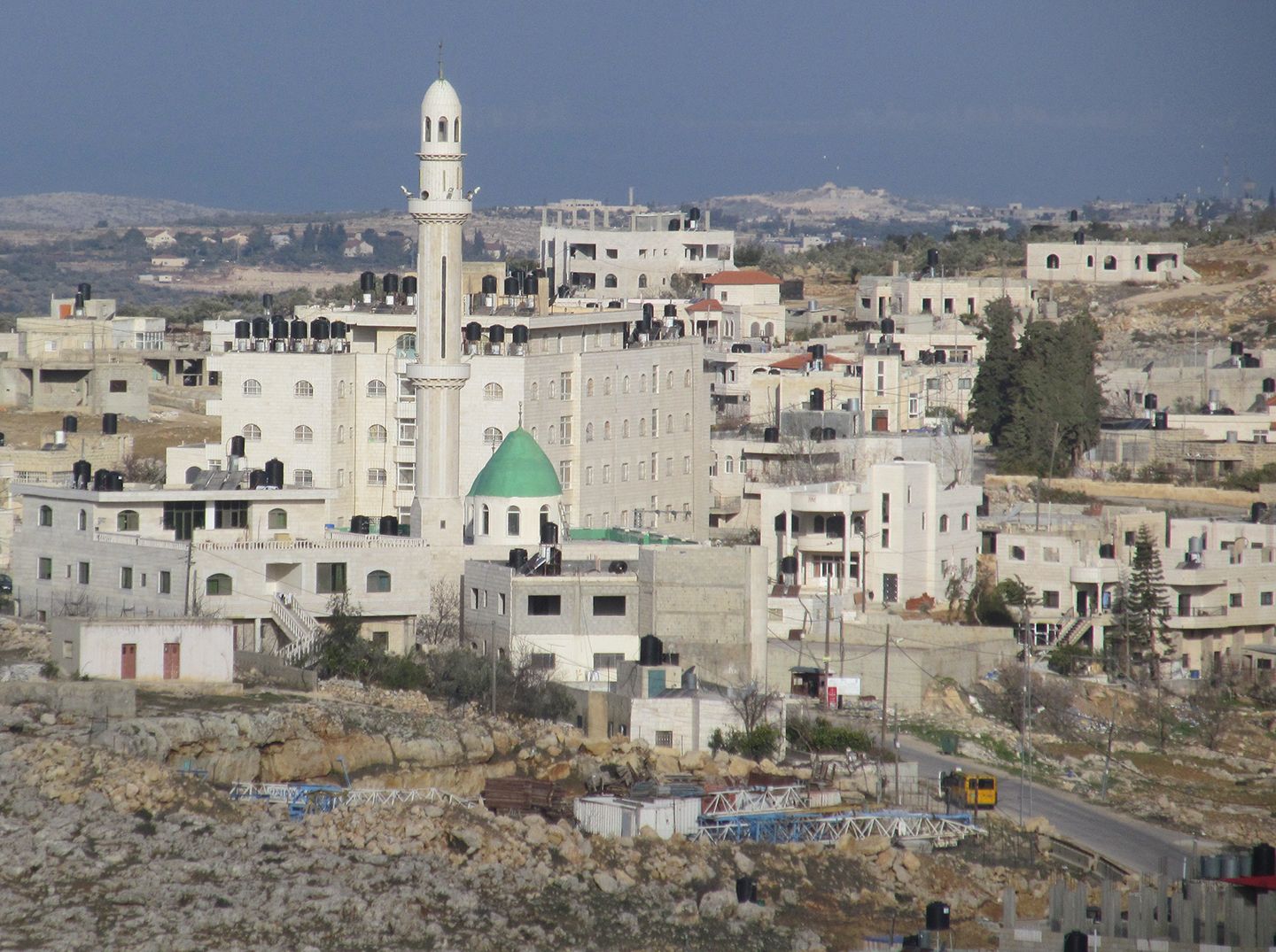 White walled residential buildings around a central minaret.