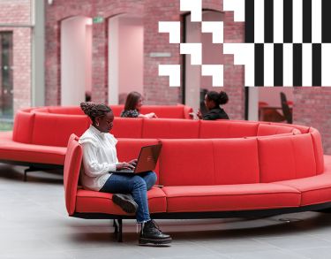 Student sitting on a couch with a laptop