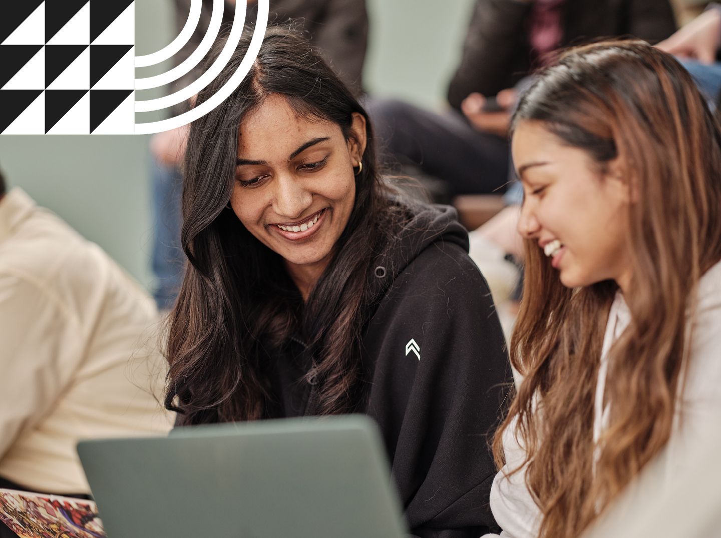 Two female students smiling in a lecture