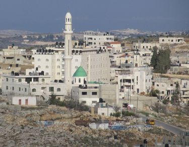 White walled residential buildings around a central minaret.