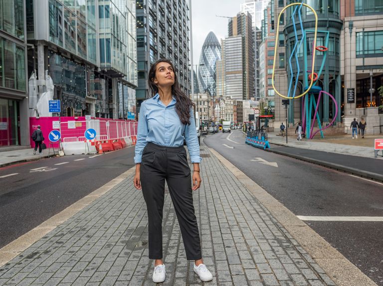 Bayes student in Central london looking up at skyscraper 