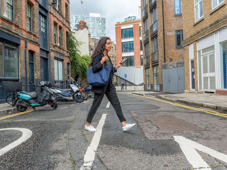 Bayes female student on phone walking through London 