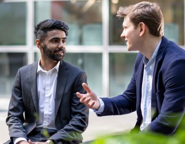Two male students talking outside 