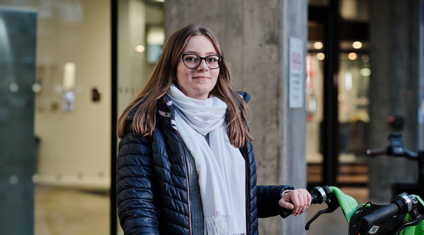 City student outside of University building with bike