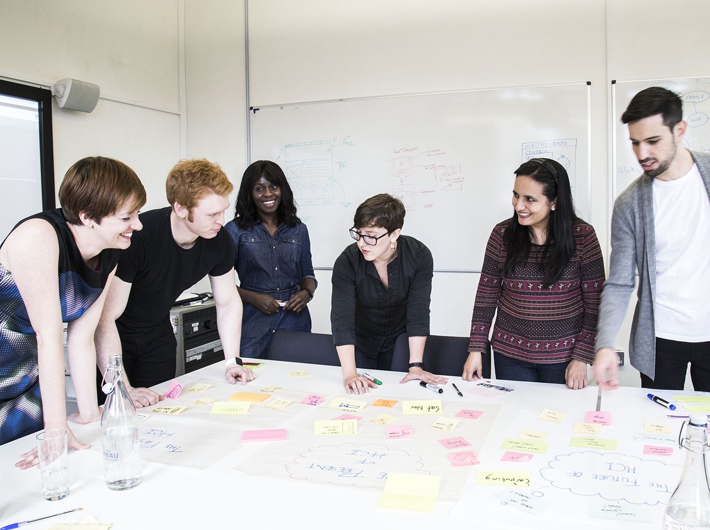 Team doing a affinity diagramming work with post-it notes.