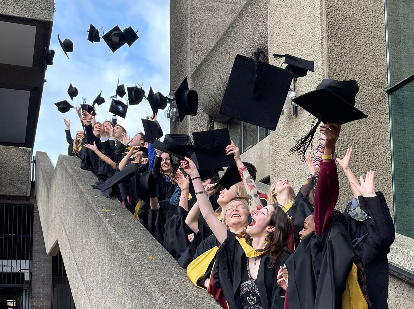 New graduates throwing their mortarboards into the air in celebration