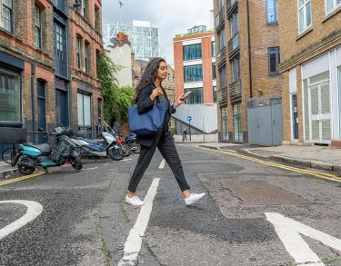 Bayes female student on phone walking through London 