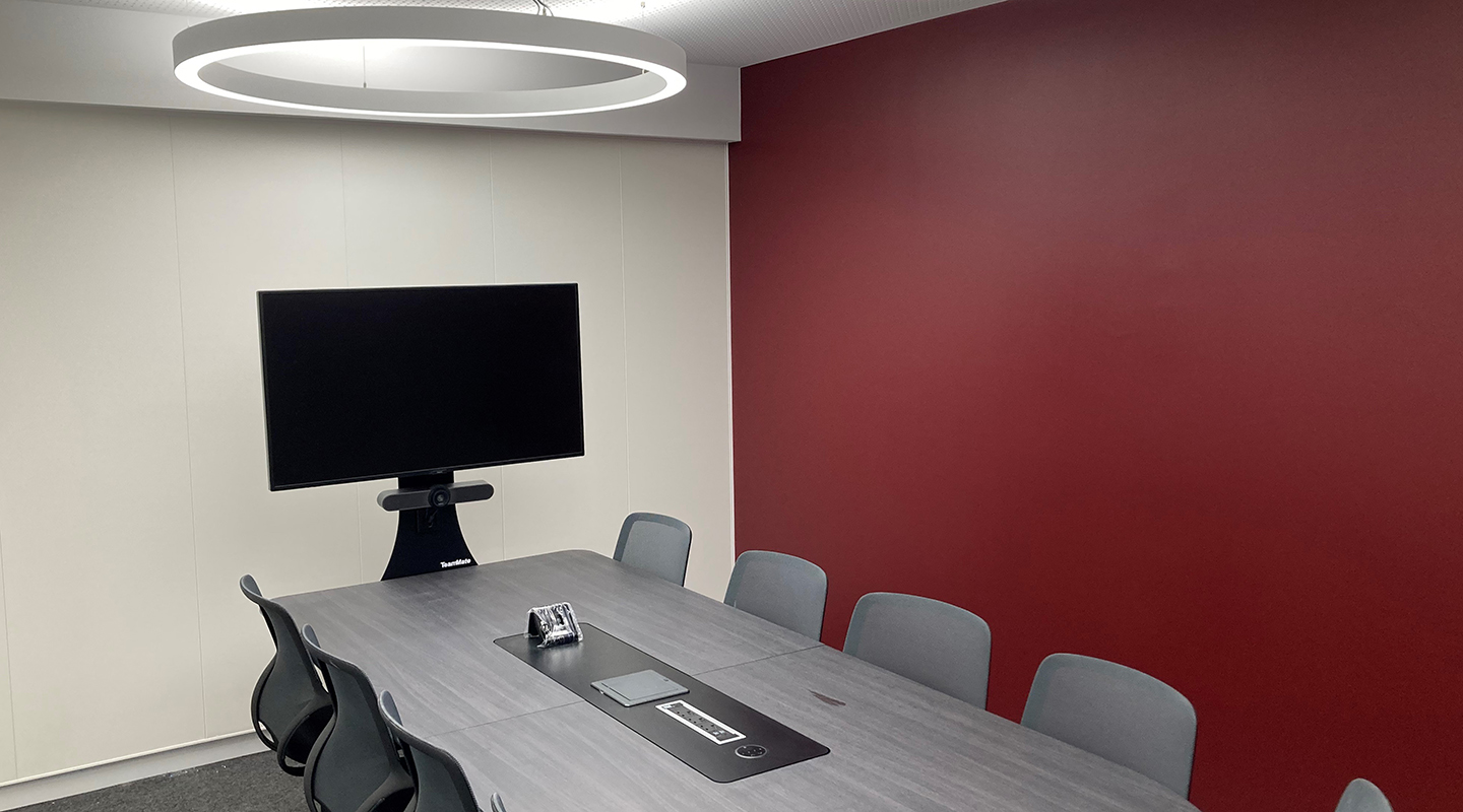 Syndicate room - boardroom style table with a monitor at one end for hybrid group work.