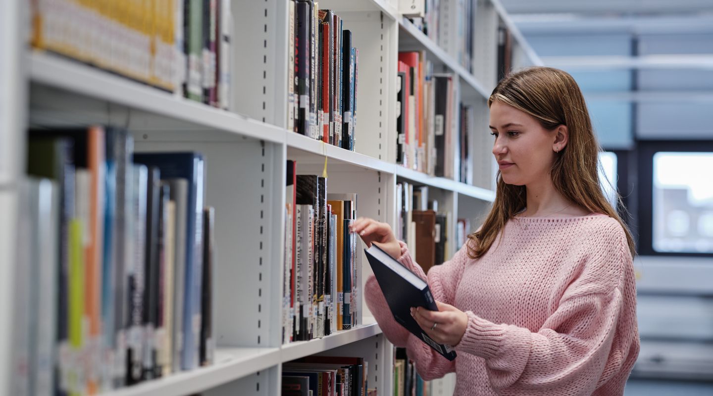 City student browses books in main library