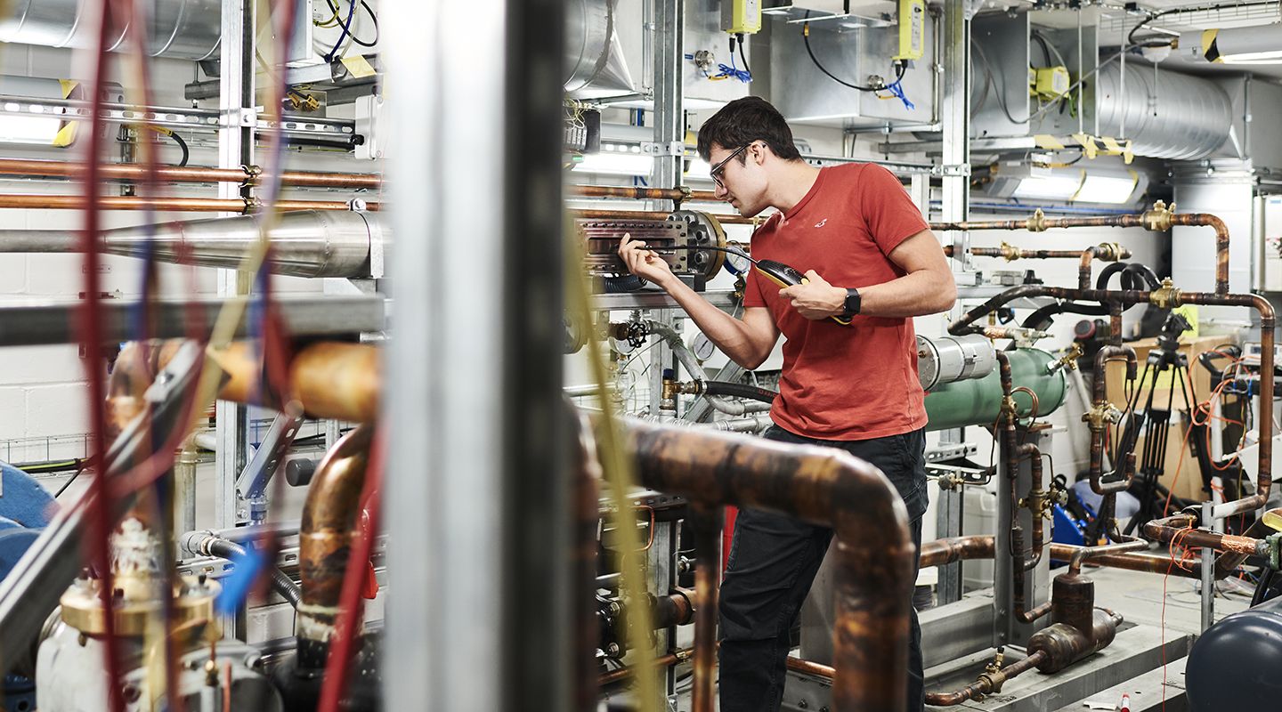 Young man working in machine lab.