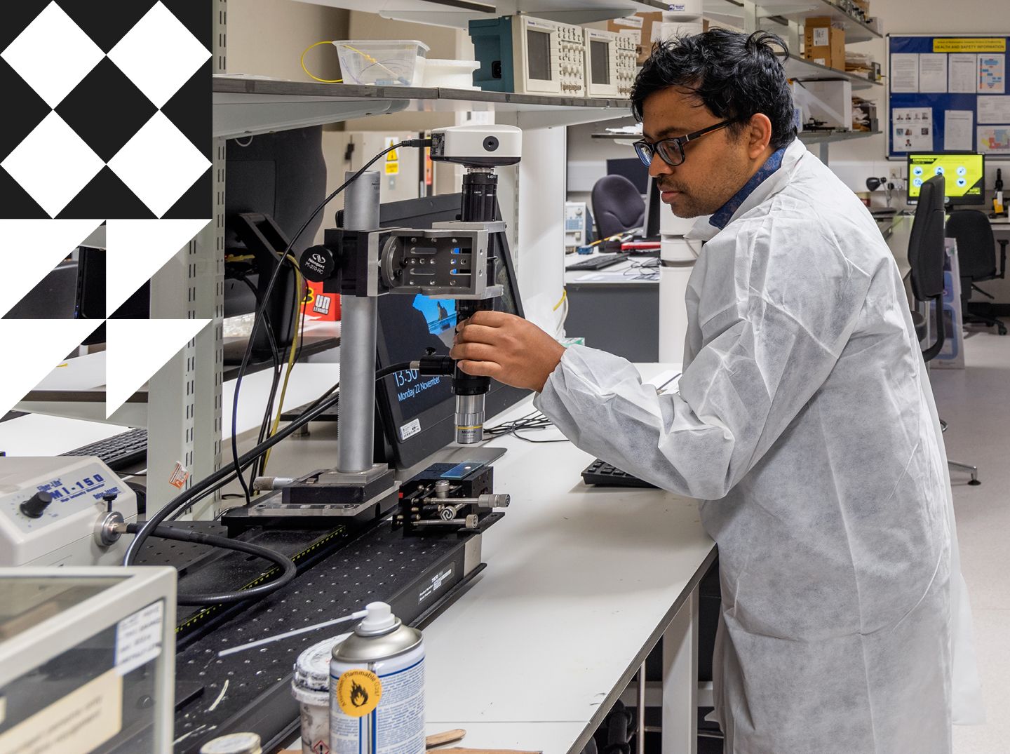 Male student in a lab coat setting up digital microscopeMale student in a lab coat setting up digital microscope.