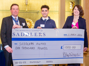 Leo Salem holding £1000 cheque from Saddlers