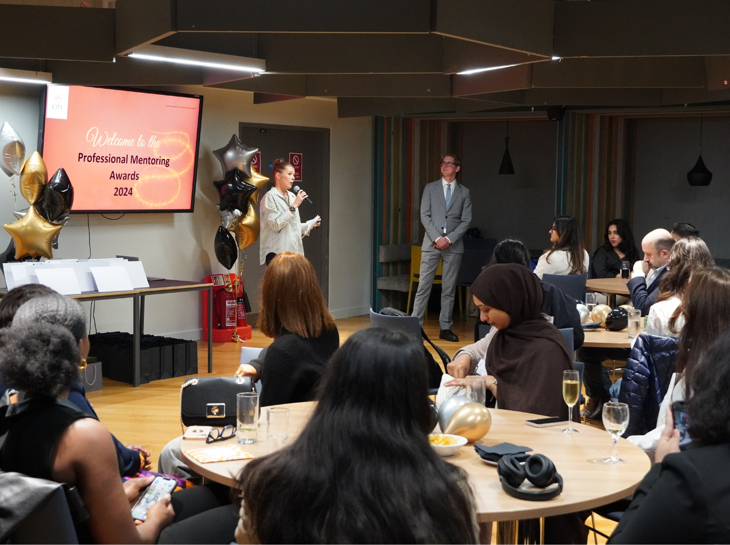Mentors and mentees seated together at awards ceremony