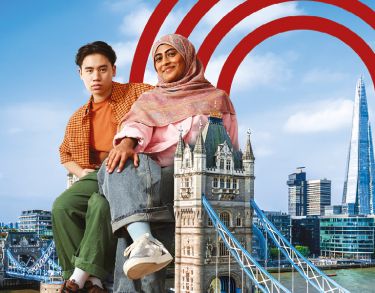 Two oversized students sitting atop a London landmark (Tower Bridge)
