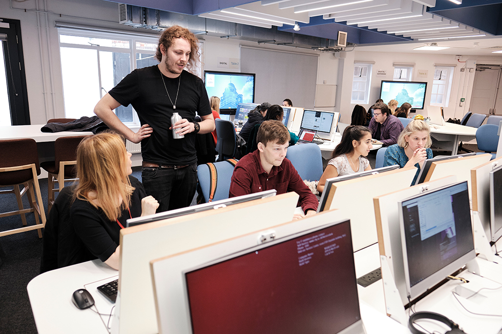 Students talking using computers in multimedia suite
