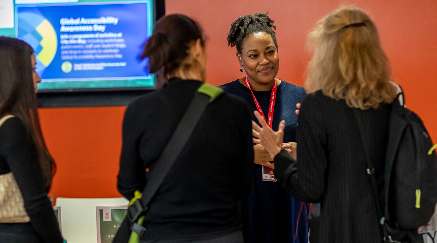 Parents, students, and a member of staff in discussion at a City open event.